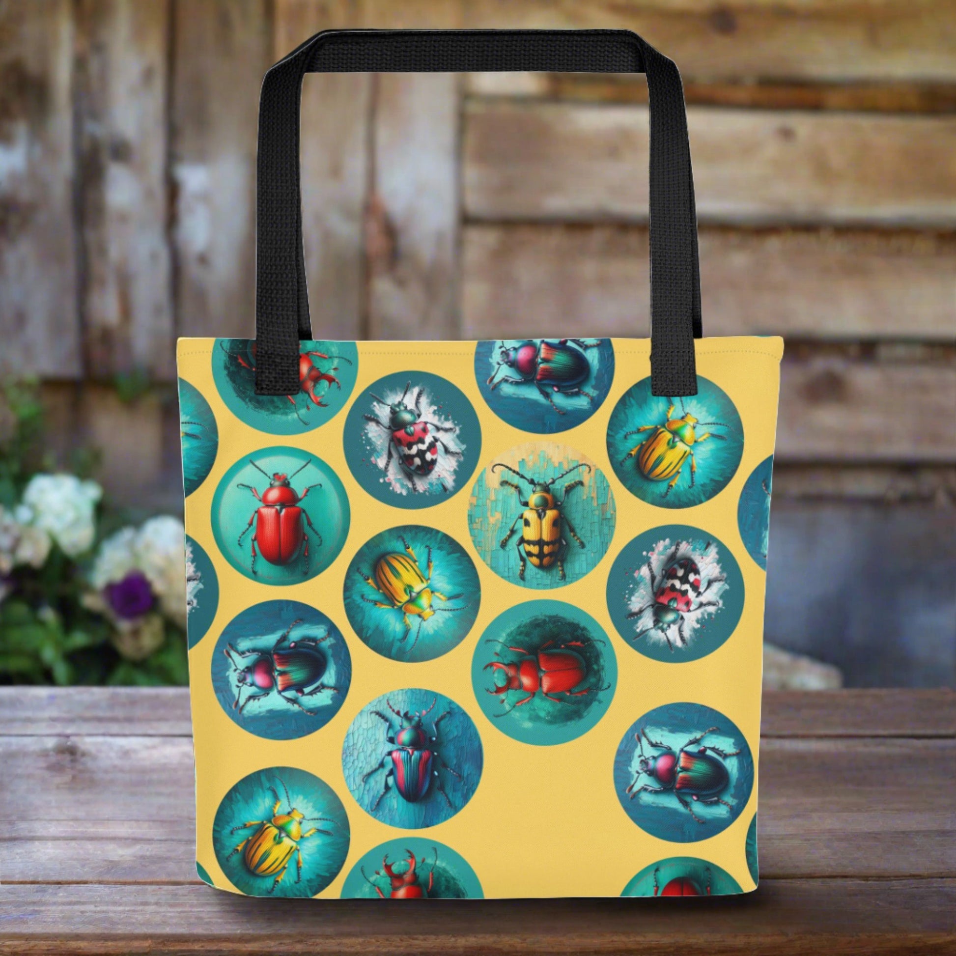 A spacious tote bag that is yellow nad covered in a magical beetle motif